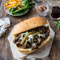 A close up shot of a oxtail cheesesteak sandwich with cheese melting 